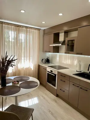 a kitchen with a table and two chairs and a table at Cozy Šmozy Apartamentai in Šiauliai