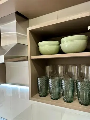 a shelf with bowls and glasses on it at Cozy Šmozy Apartamentai in Šiauliai