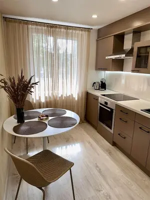 a kitchen with a table and two chairs and a table at Cozy Šmozy Apartamentai in Šiauliai