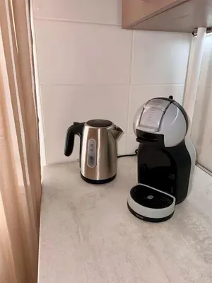 a coffee maker and a toaster sitting on a counter at Cozy Šmozy Apartamentai in Šiauliai
