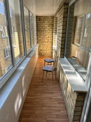 a hallway with two chairs and two windows at Cozy Šmozy Apartamentai in Šiauliai