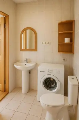 a bathroom with a toilet sink and a washing machine at Home in Santariskes in Vilnius