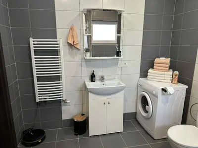 a bathroom with a washing machine and a sink at Modern apartment with balcony in Užliedžiai