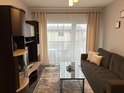 a living room with a couch and a glass table at Modern apartment with balcony in Užliedžiai