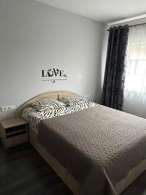 a bedroom with a bed and a sign that says leave at Modern apartment with balcony in Užliedžiai