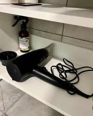 a black microphone on a shelf with a bottle of sauce at DvaroStudio jaukus butas centre self-check-in in Šiauliai