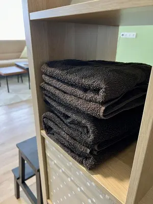 a group of towels are stacked in a closet at DvaroStudio jaukus butas centre self-check-in in Šiauliai
