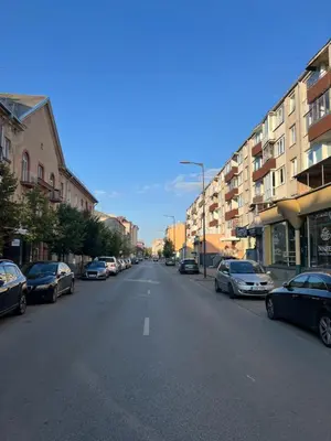 an empty city street with parked cars and buildings at DvaroStudio jaukus butas centre self-check-in in Šiauliai