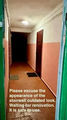 a hallway with a room with a door and a sign at DvaroStudio jaukus butas centre self-check-in in Šiauliai
