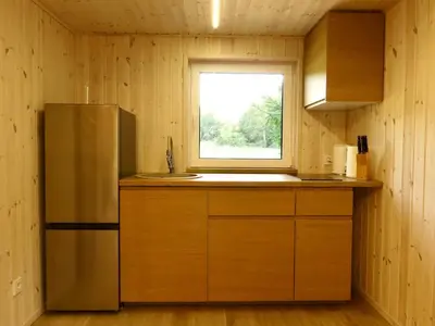 a kitchen with a refrigerator and a window at Gray House in Marijampolė