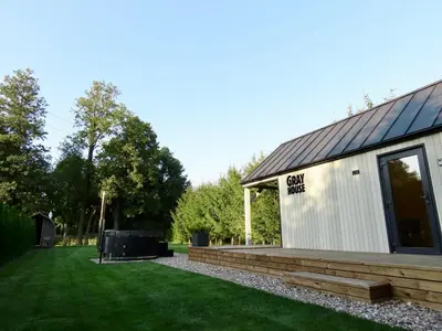 a white building with a deck next to a yard at Gray House in Marijampolė
