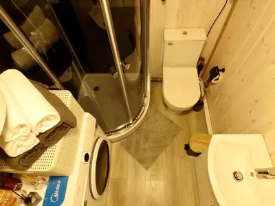a small bathroom with a toilet and a sink at Gray House in Marijampolė