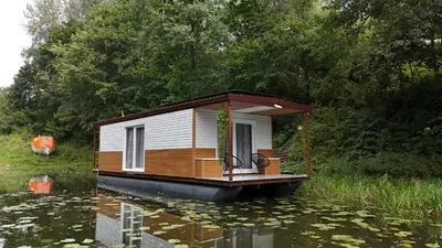 a small house on a boat in the water at Houseboat Vilnius in Vilnius