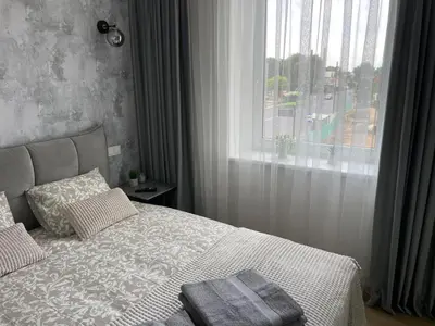 a bedroom with a large bed with a window at Stylish Apartment 5 min from Kaunas Clinics in Kaunas