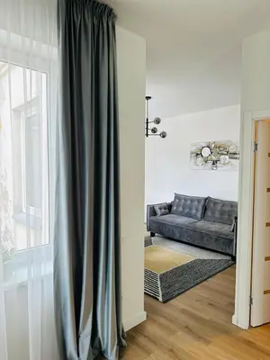 a living room with a couch and a window at Stylish Apartment 5 min from Kaunas Clinics in Kaunas
