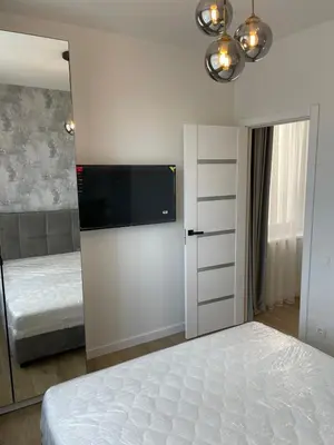 a bedroom with a bed and a tv on the wall at Stylish Apartment 5 min from Kaunas Clinics in Kaunas