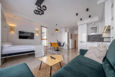 a living room with a couch and a bed and a table at King Mindaugas Apartments in Kaunas
