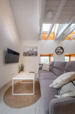 a living room with a gray couch and a table at King Mindaugas Apartments in Kaunas