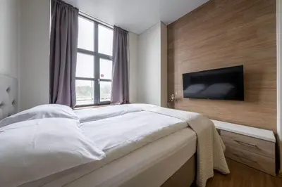 a bedroom with a large bed and a television at King Mindaugas Apartments in Kaunas