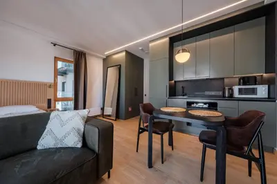 a living room with a couch and a table with chairs at King Mindaugas Apartments in Kaunas