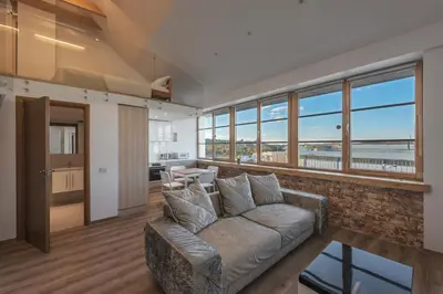 a living room with a couch and a view of the ocean at King Mindaugas Apartments in Kaunas