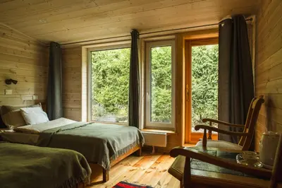a bedroom with two beds and two windows at Kaimo turizmo sodyba Kukarskė in Kiduliai