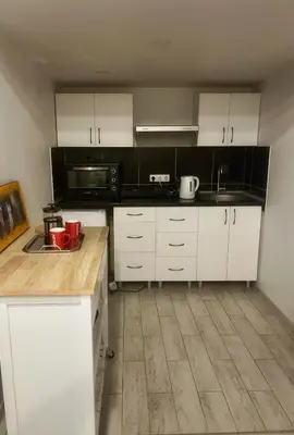a kitchen with white cabinets and black appliances at Tech City Apartments, Nr Vilnius Old Town in Vilnius