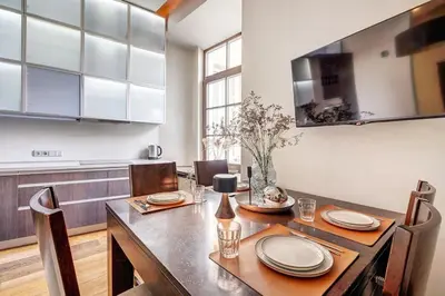 a dining room with a table and chairs and a kitchen at Domillion Quiet 2bdr apt w panorama & balcony B83 in Vilnius