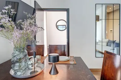 a dining room table with a vase of flowers on it at Domillion Quiet 2bdr apt w panorama & balcony B83 in Vilnius