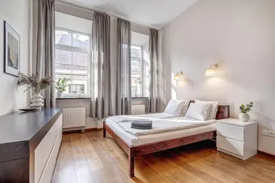a bedroom with a bed in a room with windows at Domillion Quiet 2bdr apt w panorama & balcony B83 in Vilnius
