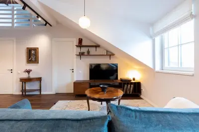 a living room with a couch and a table and a tv at Domillion 2bdr old town apt at Bazilijonai in Vilnius
