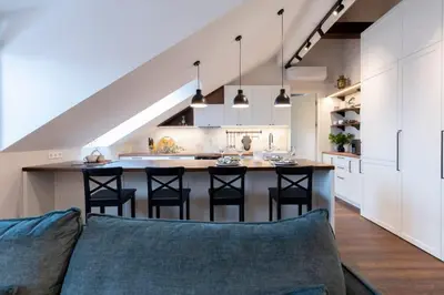 an open kitchen with a couch and a kitchen island at Domillion 2bdr old town apt at Bazilijonai in Vilnius