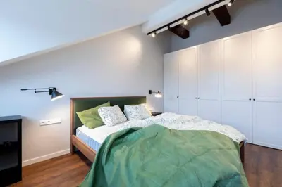 a bedroom with a large bed and a tv at Domillion 2bdr old town apt at Bazilijonai in Vilnius