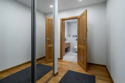 a bathroom with a toilet and a door with a mirror at Domillion 1bdr lovely apt with parking &lift B9a4 in Vilnius
