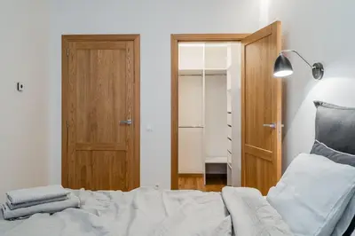 a bedroom with a bed and a wooden door at Domillion 1bdr lovely apt with parking &lift B9a4 in Vilnius