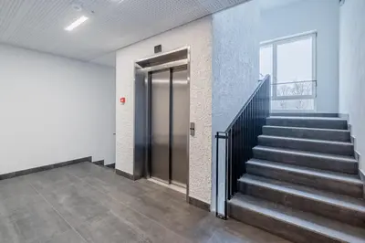 a hallway with stairs and a door in a building at Domillion 1bdr lovely apt with parking &lift B9a4 in Vilnius