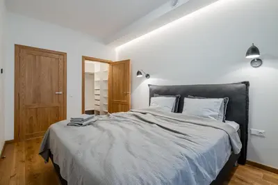 a bedroom with a large bed with a black headboard at Domillion 1bdr lovely apt with parking &lift B9a4 in Vilnius