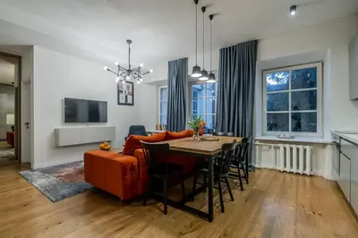 a living room with a table and a couch at Domillion New City Hall Duplex D11C for 12 ppl in Vilnius