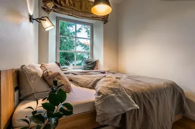 a bedroom with a bed and a window at Domillion New City Hall Duplex D11C for 12 ppl in Vilnius