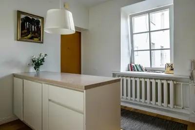a kitchen with a white counter and a window at Domillion New City Hall Duplex D11C for 12 ppl in Vilnius