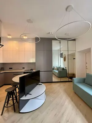 a living room with a table and a blue couch at Domillion 2bdr new apt on Pilies st in Vilnius