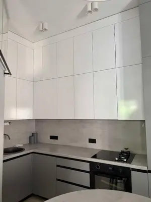 a white kitchen with white cabinets and a stove at Domillion 2bdr new apt on Pilies st in Vilnius