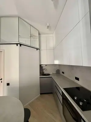 a kitchen with white cabinets and a table in it at Domillion 2bdr new apt on Pilies st in Vilnius