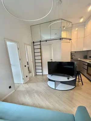 a living room with a couch and a kitchen at Domillion 2bdr new apt on Pilies st in Vilnius