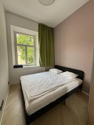 a bedroom with a large bed with a window at Domillion 2bdr new apt on Pilies st in Vilnius