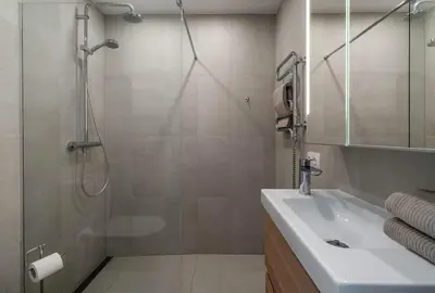 a bathroom with a shower and a sink and a glass shower door at Domillion New Duplex 12ppl balconies free park N2A in Vilnius