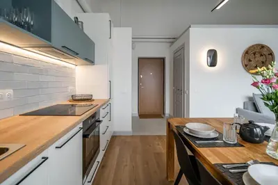 a kitchen with white appliances and a wooden counter top at Domillion New Duplex 12ppl balconies free park N2A in Vilnius