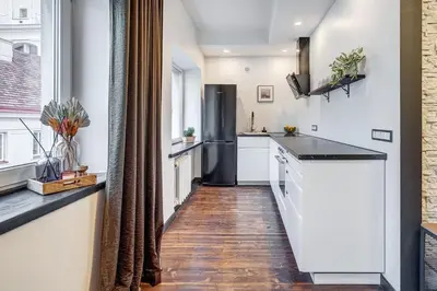 a kitchen with white cabinets and a refrigerator at Domillion 1bdr Dominikonu str apt Do333 in Vilnius