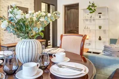 a table with a vase with white flowers on it at Domillion 1bdr Dominikonu str apt Do333 in Vilnius