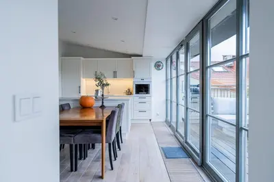 a kitchen with a wooden table and a dining room at Domillion Amazing 3bdr Penthouse with Terrace MZ28 in Vilnius